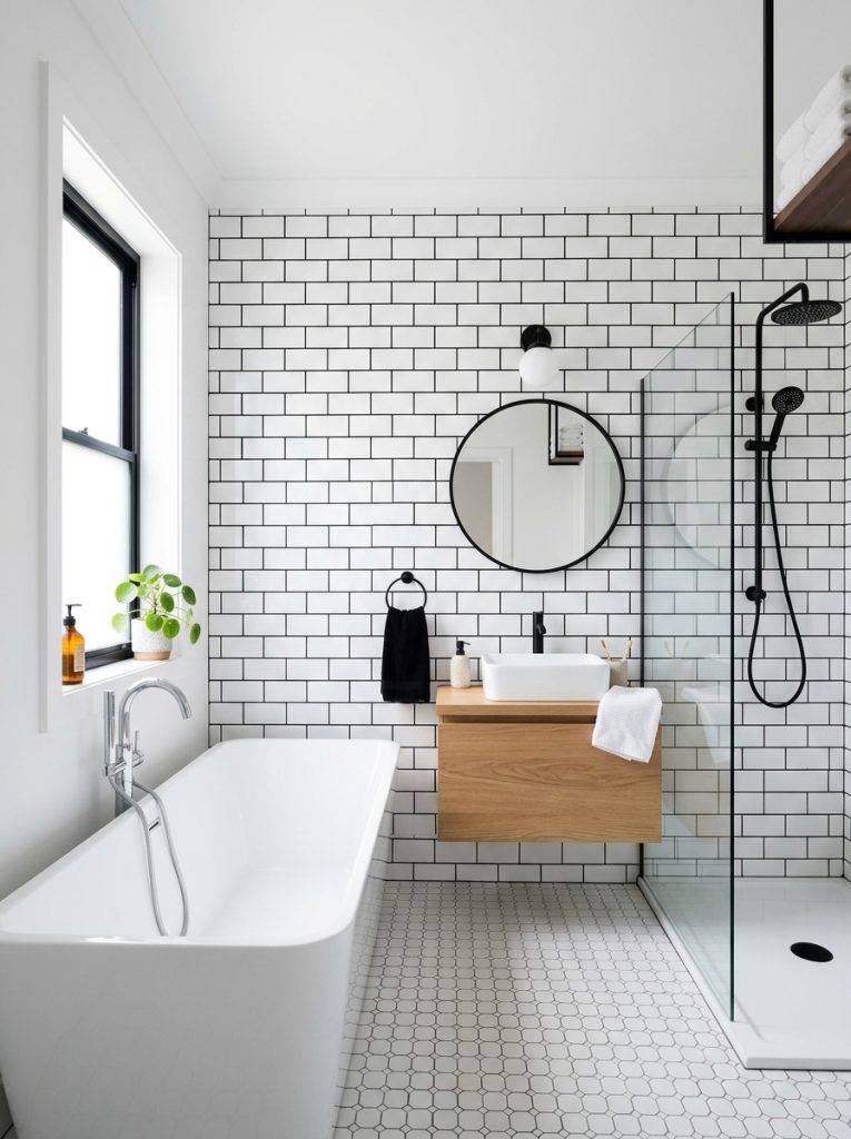 Classic white subway tiles with bold black grout in a clean modern bathroom with bright natural light and modern fixtures