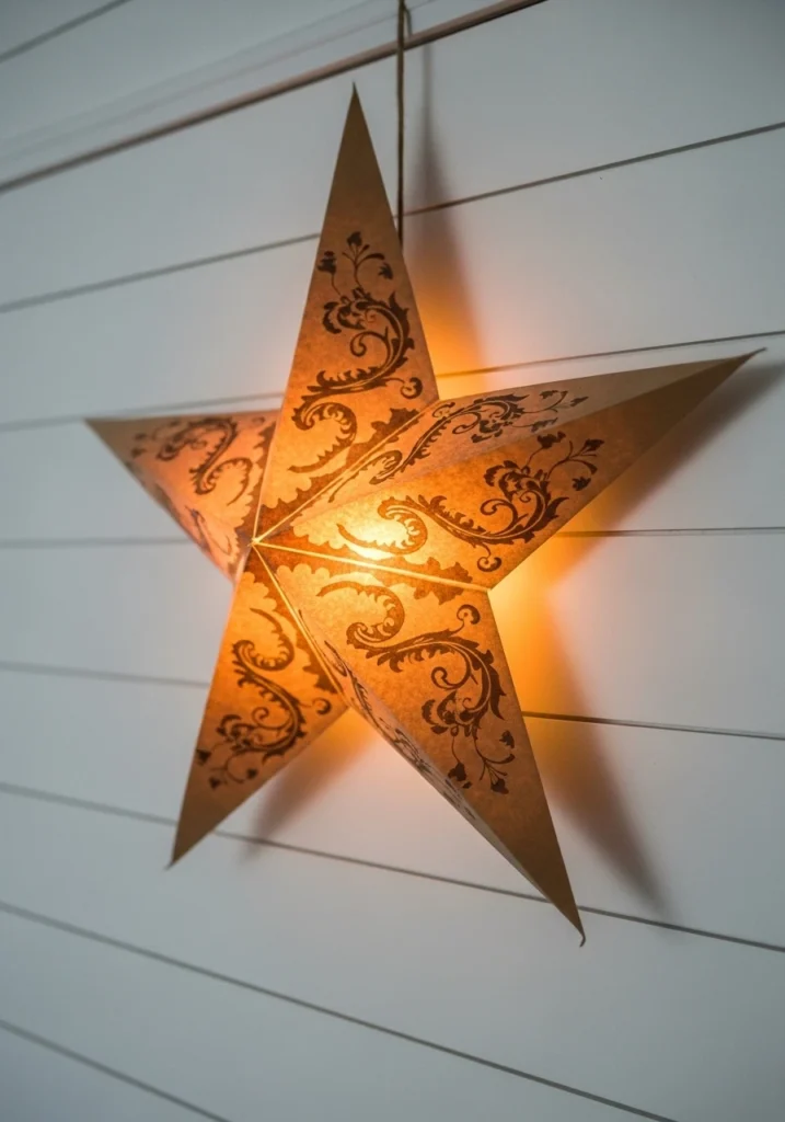 Brown paper bag star with LED light glowing against white wall