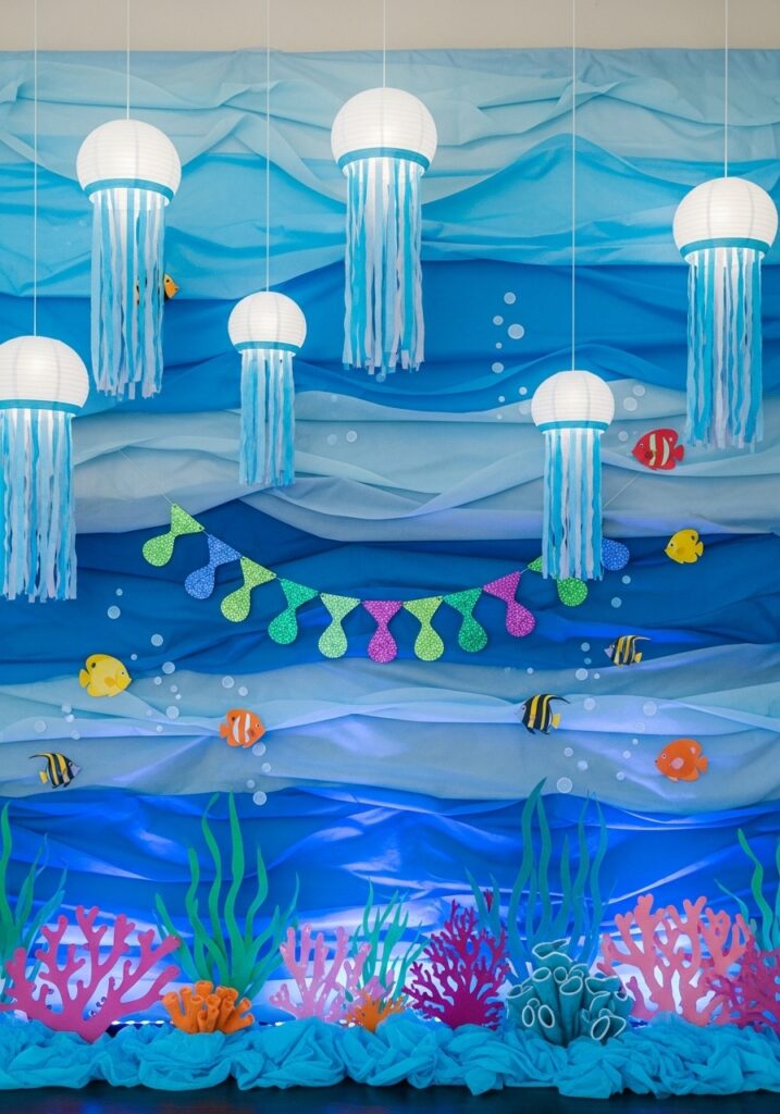 Under the sea baby shower backdrop with ocean waves and marine decorations