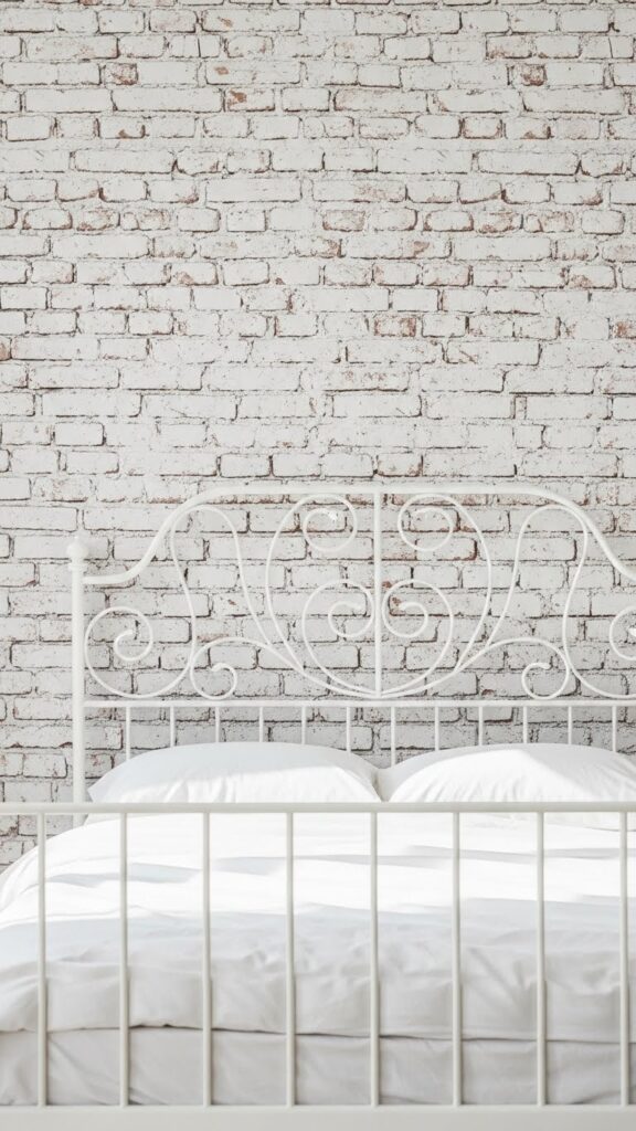 White painted brick accent wall showing rustic texture while maintaining clean white bedroom aesthetic