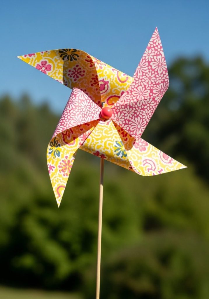 Cheap paper windmill craft kids bright square patterned paper folded cut pinwheel shape wooden skewer bead center finished paper windmill cheerful pink yellow spinning breeze sunny summer day