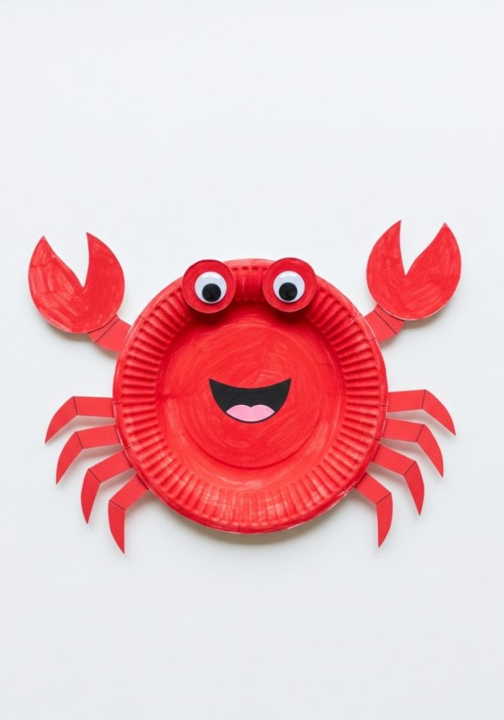 Preschool paper plate crab craft red painted paper plate crab body eight red paper strip legs googly eyes smiling mouth white background cheerful fun achievable preschool