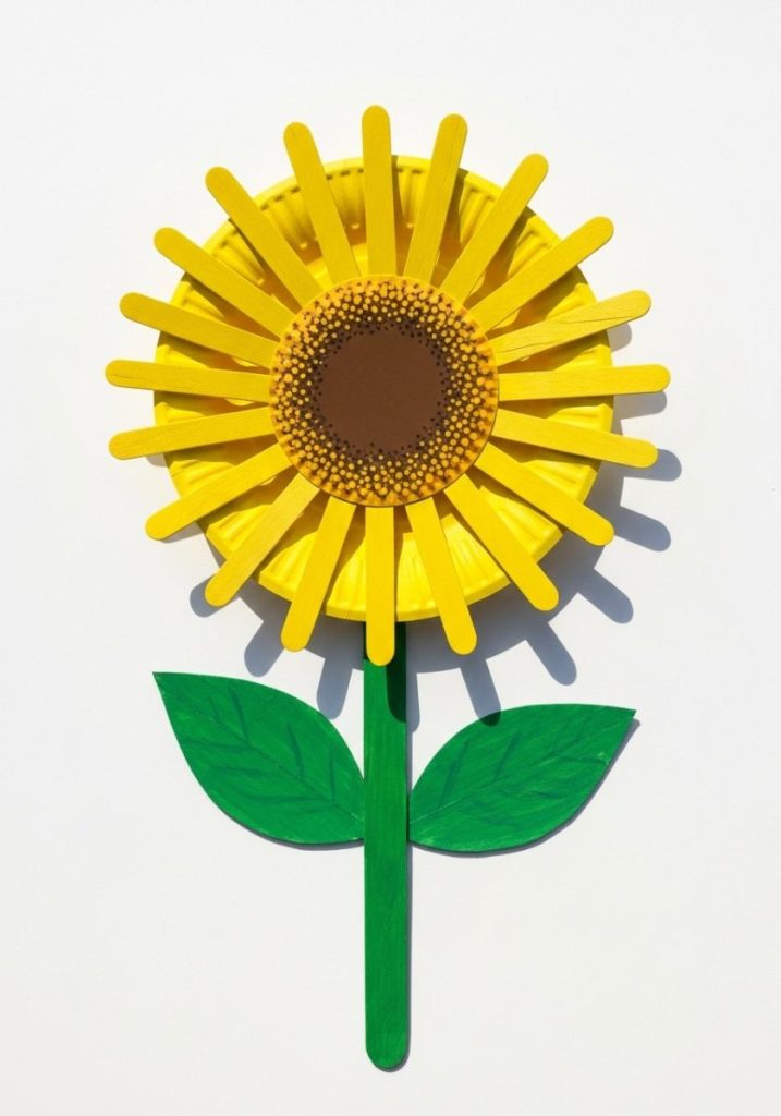 Paper plate sunflower craft kids yellow paper plate bright yellow popsicle stick petals green cardboard stem leaves bright cheerful summery