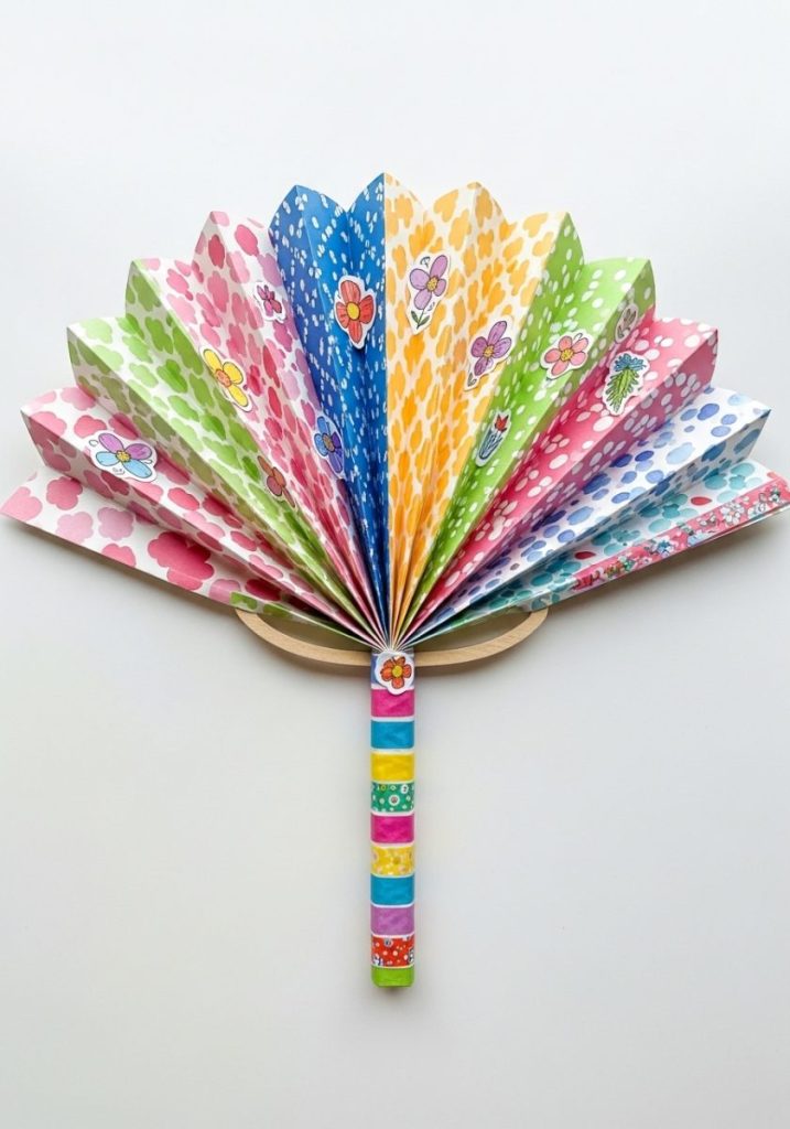 Cute paper fan craft kids bright patterned paper accordion folded fan shape colourful washi tape handle stickers drawn flowers cheerful colourful functional actual summer fan