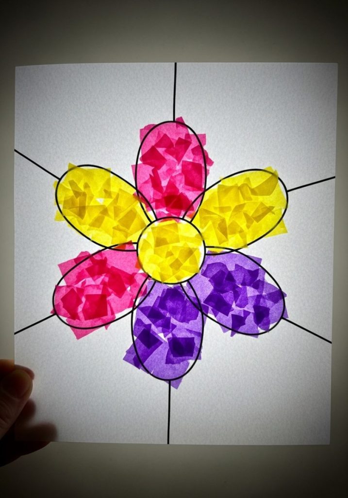 Tissue paper stained glass mothers day craft kids simple flower outline white card torn tissue paper pink yellow purple glued inside lines held up light glowing beautifully vibrant creative stunning child-made