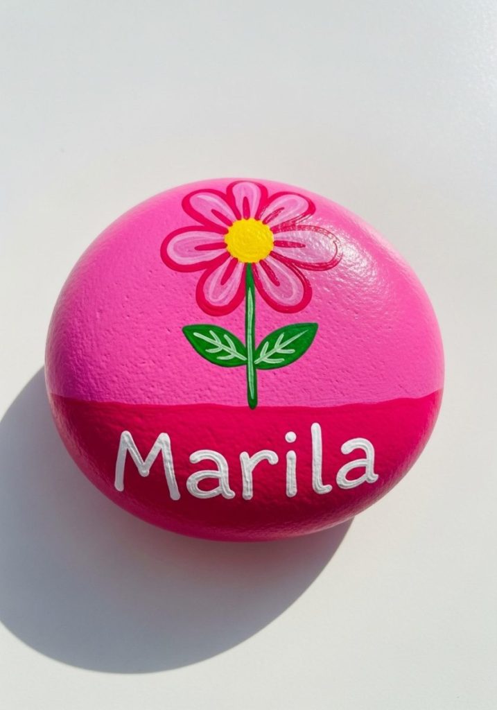 Painted rock mothers day craft kids smooth round stone bright pink simple flower design white paint child's name cheerful handmade genuinely useful sweet gift
