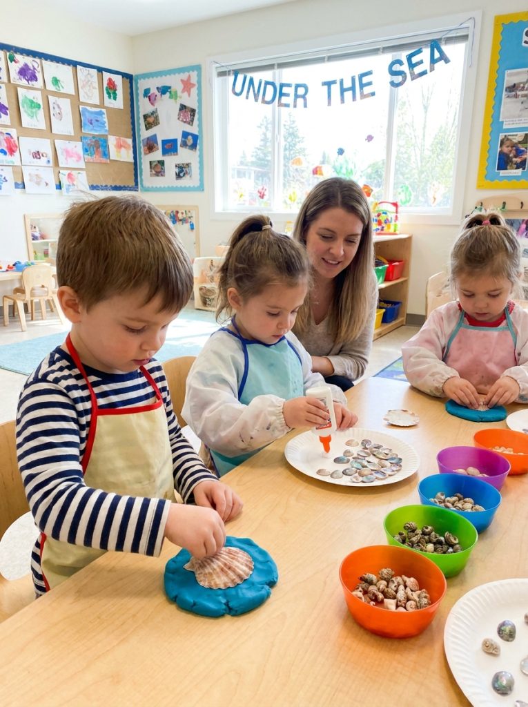 Adorable preschool seashell crafts with young children pressing shells into playdough making prints gluing on paper and sorting shells