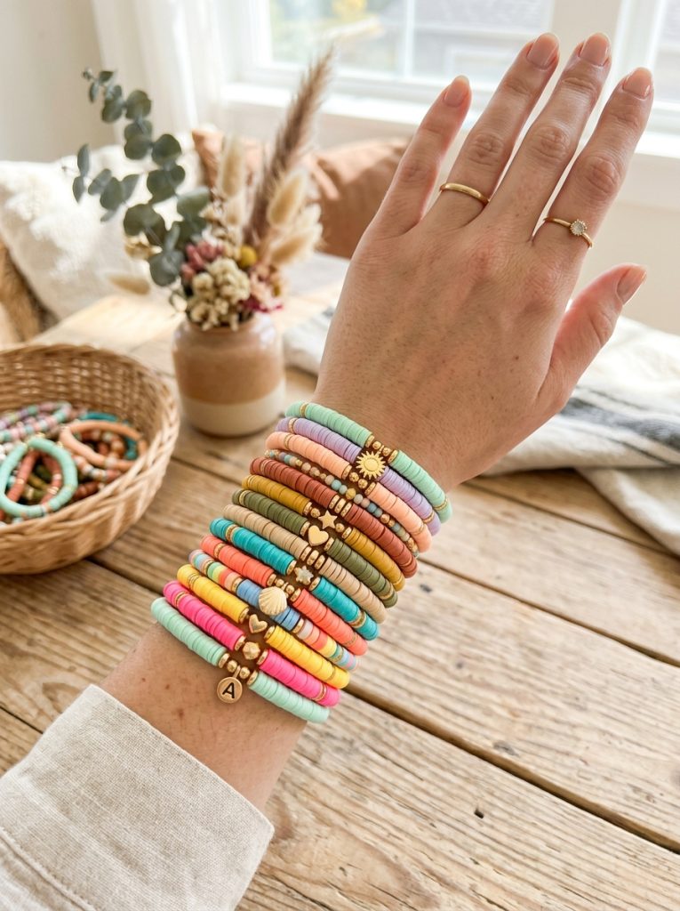Beautiful homemade clay bead bracelet ideas with multiple bracelets in pastel aesthetic earth and summer tones stacked on wrist