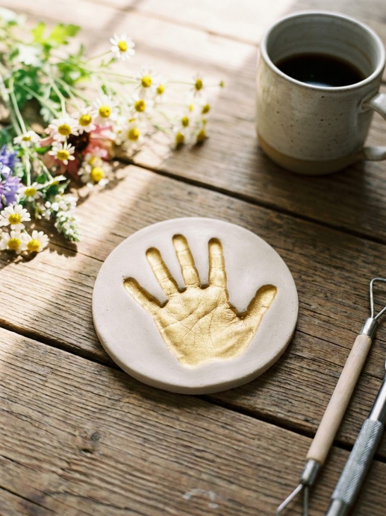  Finished gold clay handprint keepsake disc for fathers day on wooden table