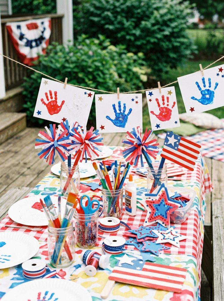 Colorful 4th of July craft table with red white blue handprints patriotic foam stars tissue paper fireworks and flag crafts