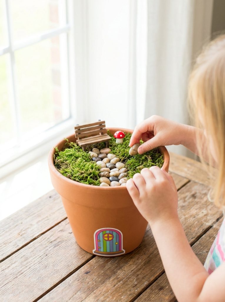  Simple easy beginner fairy garden in terracotta pot with tiny door pebble path and moss