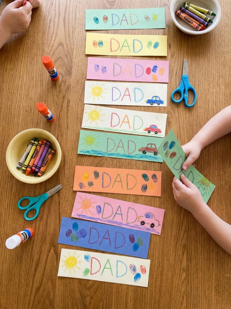 Cute colorful preschool fathers day bookmarks with fingerprints and dad written on them