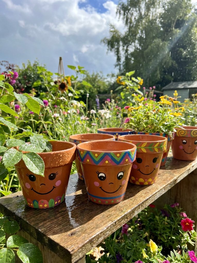 Beautifully sealed outdoor flower pot faces DIY with clear protective finish maintaining vibrant face details through rain sun and seasons