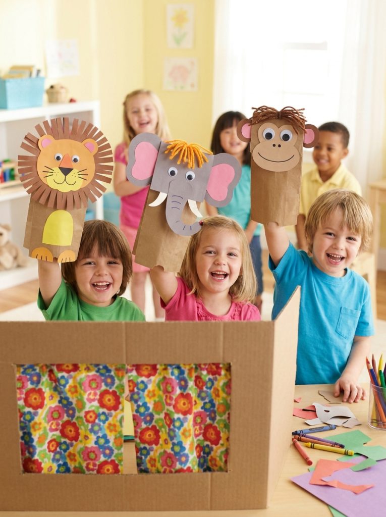 Paper bag puppets decorated as colorful animals with googly eyes and yarn hair in kids puppet show