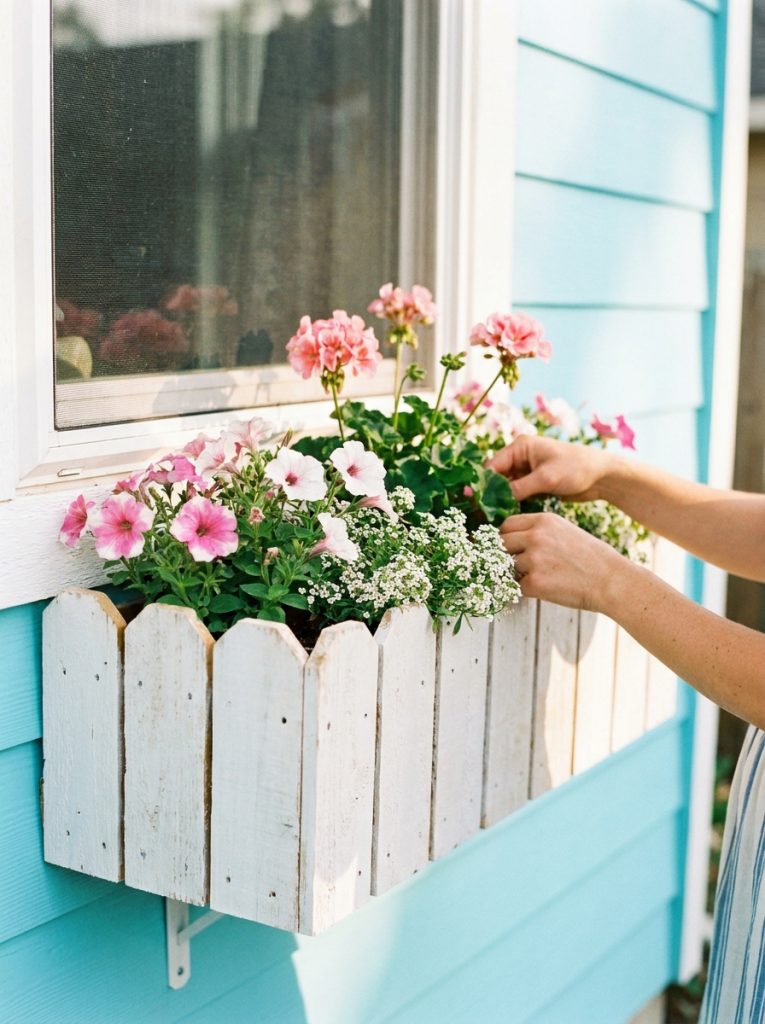  DIY window box built from cedar fence pickets painted white with pink and white flowers below window