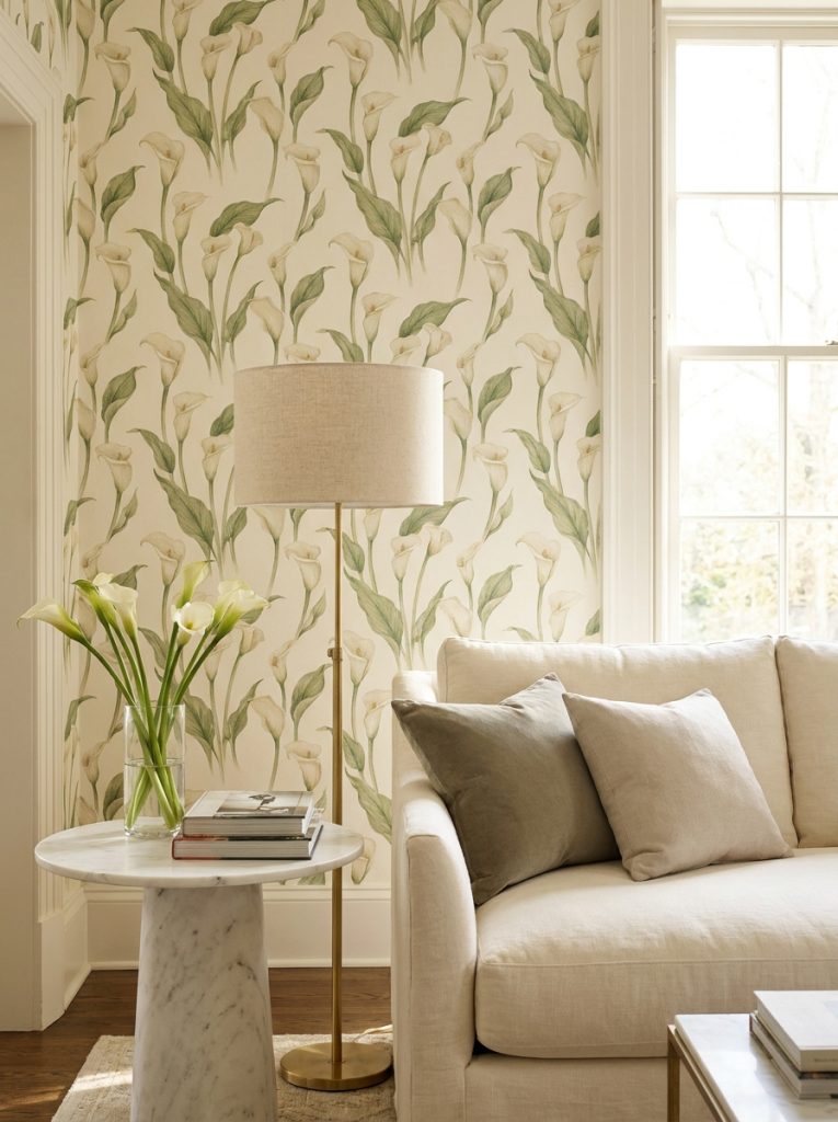 Elegant refined living room with calla lilies wallpaper cream linen sofa marble side table and slim floor lamp.