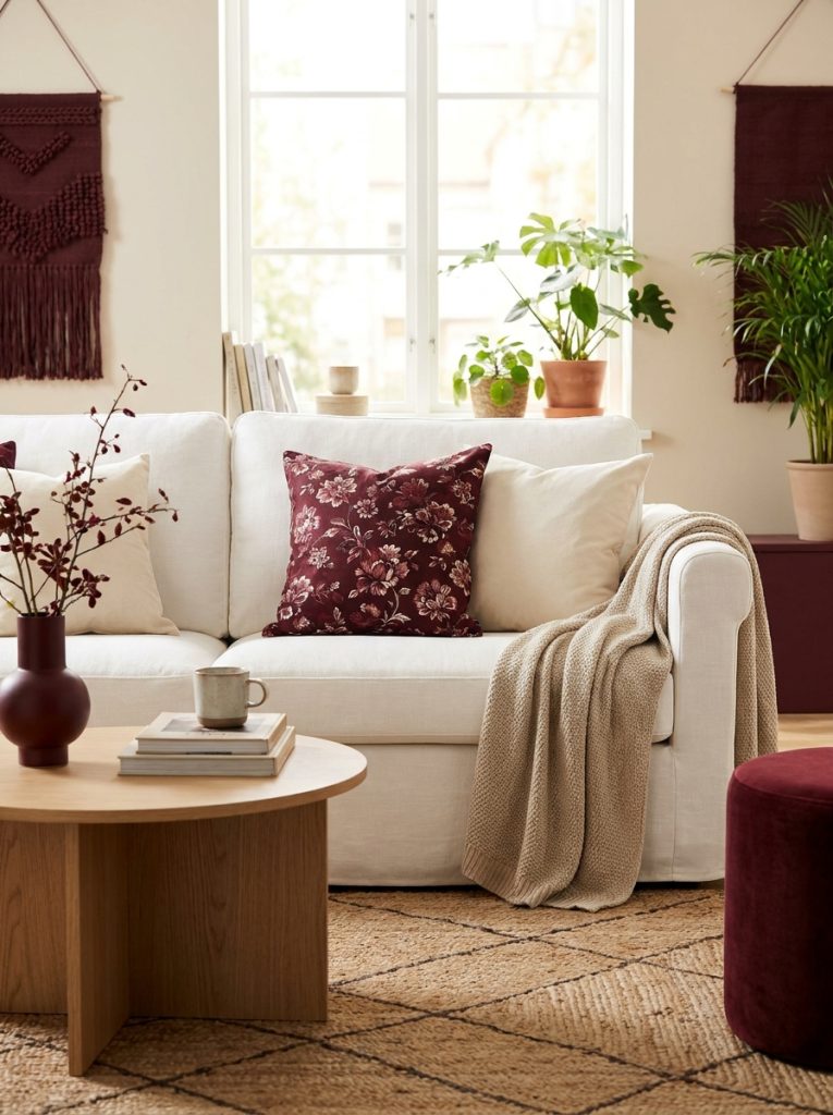 Beautiful white sofa with dark red floral throw pillow cream cushions soft throw and minimal coffee table